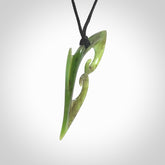 This photo shows a koru pendant carved from New Zealand Jade. The artist, Shaun Gardiner, has carved this beautifully. We provide this piece with an adjustable black cord. This is a fantastic work of art, we have one only.
